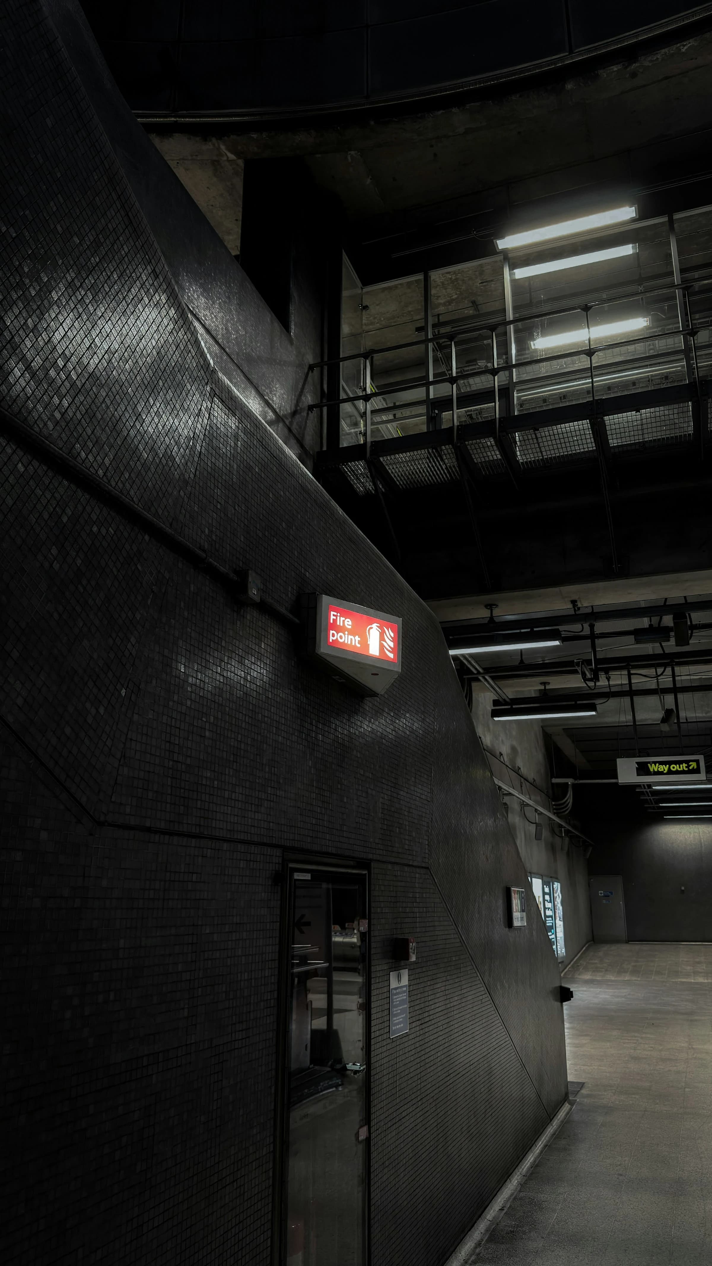 Red fire point sign in a dark industrial hallway