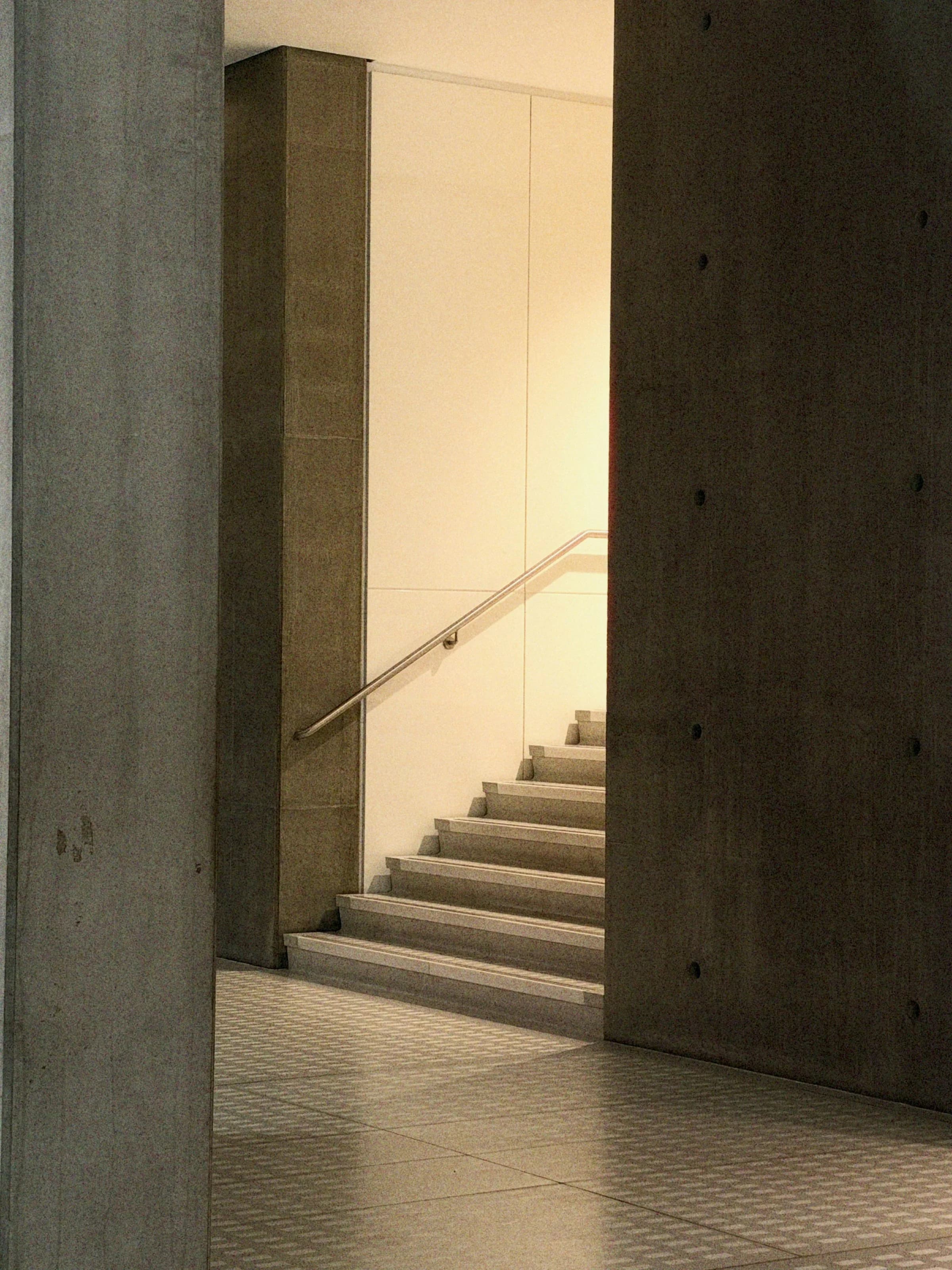 Sunlight falling across a stairwell framed by concrete walls